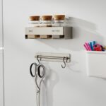 白い冷蔵庫の側面に、マグネット式の収納グッズが取り付けられている。スパイスラック、ハサミ用のフック、文房具が入った小物入れがある。